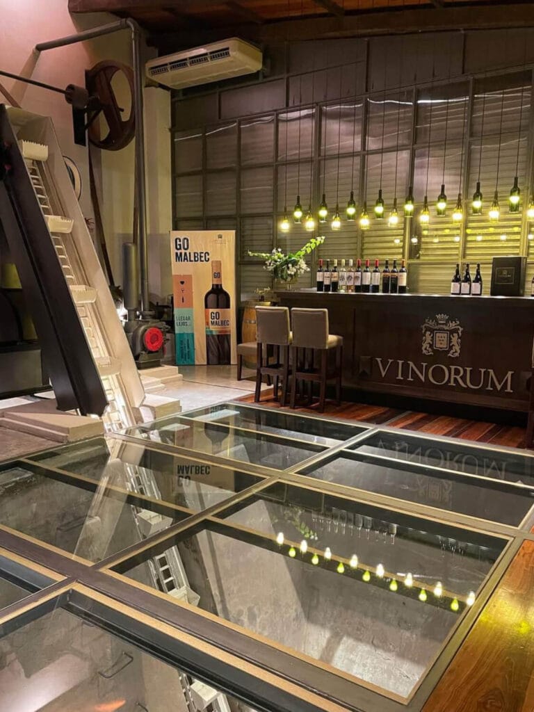 Maquinaria antigua y suelo de vidrio en Bodega Vinorum, Luján de Cuyo - Mendoza Wine Transfers