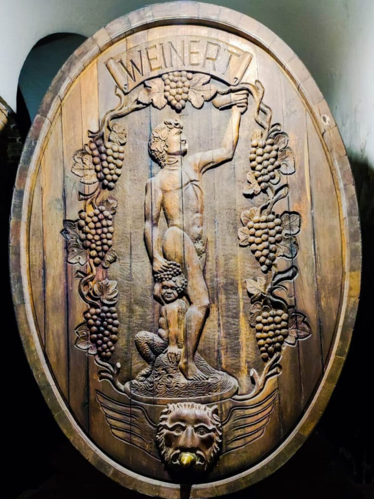 Gran tonel de roble tallado con el escudo de Bodega Weinert, Luján de Cuyo - Mendoza Wine Transfers